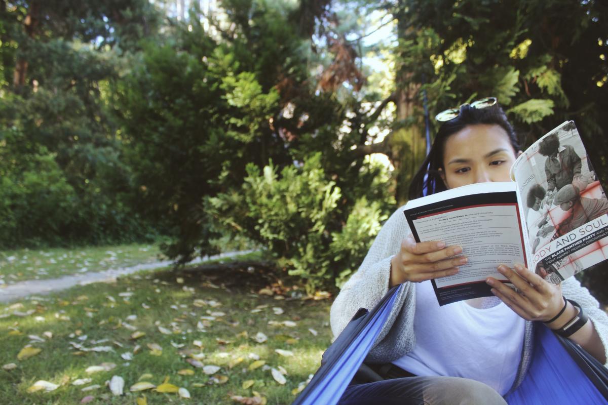 Angelica Sagun reading a book while relaxing in a hammock.