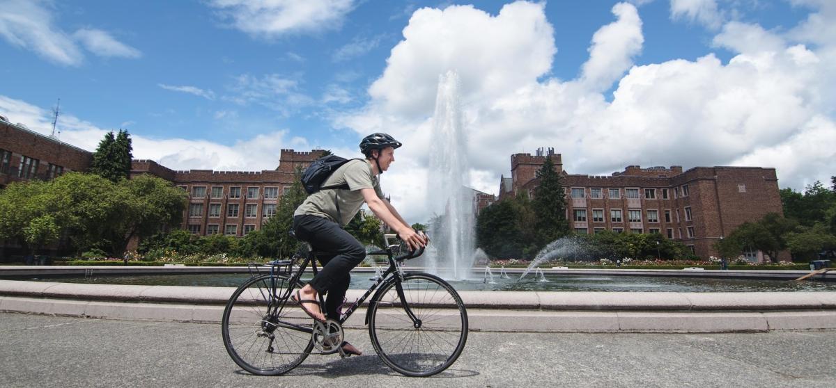 student biking by Drumheller fountain
