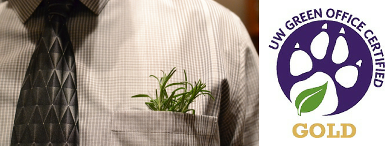 A closeup of a person in a shirt and tie with a plant in the breast pocket next to the Green Office logo.
