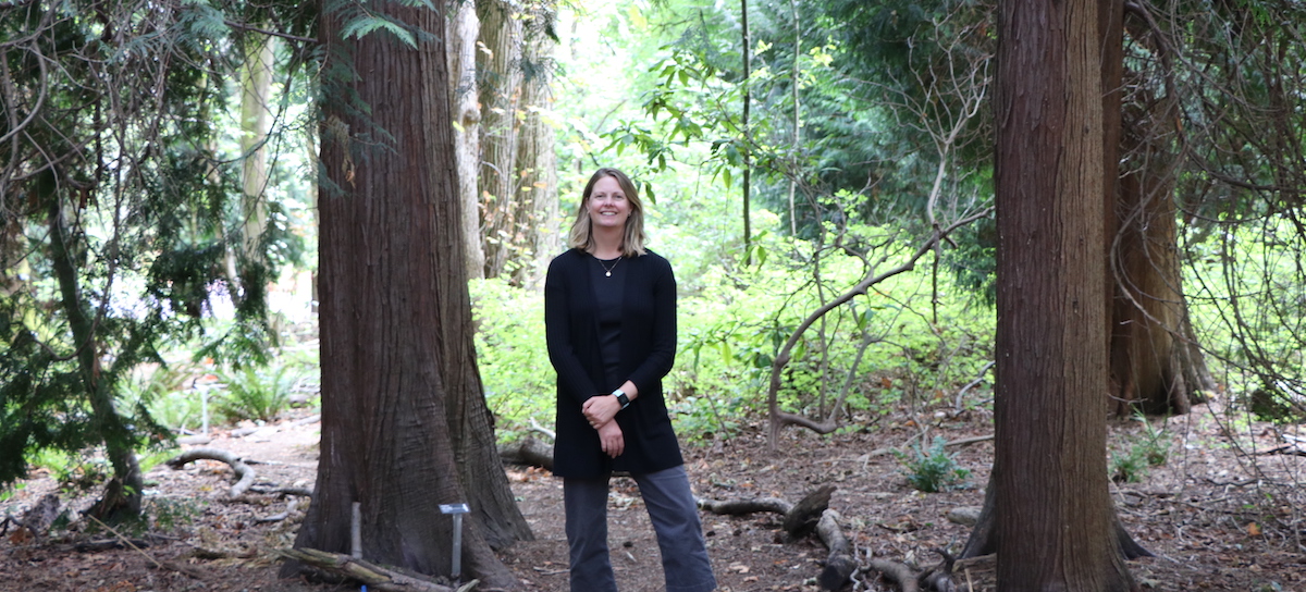 UW Sustainability Director Lisa Dulude in a wooded space on the UW campus