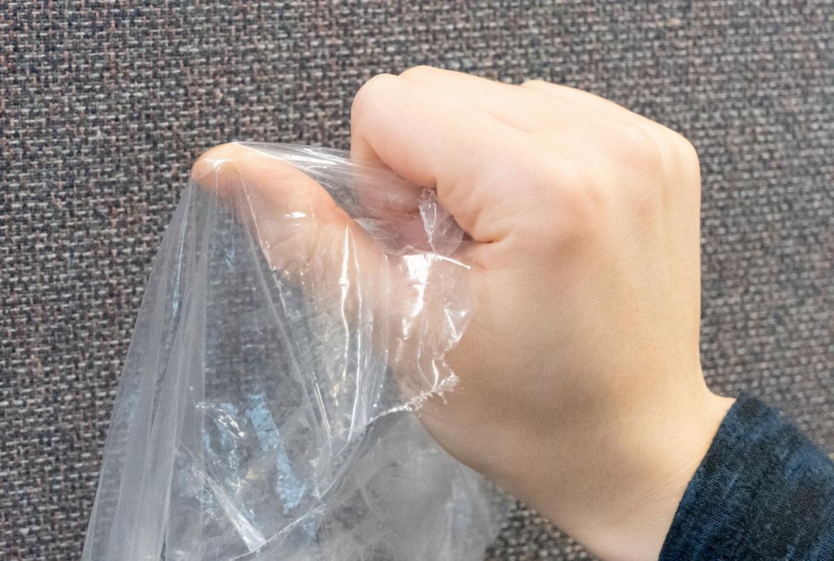 person stretching plastic film