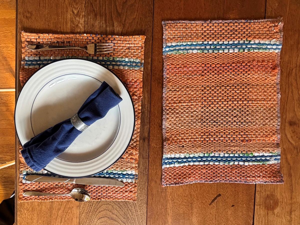two placemats on a table with one place set with dishware