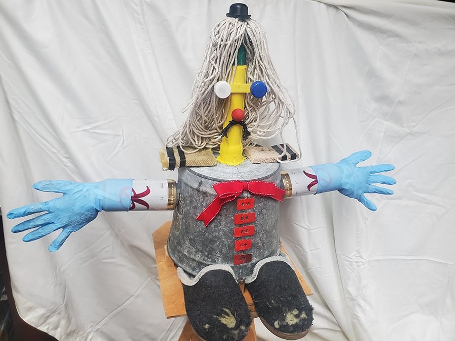 A whimsical figure made from household trash item