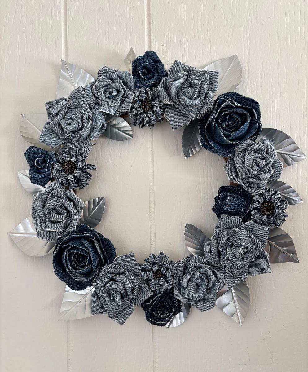 a wreath with blue jean rosettes and metal leaves
