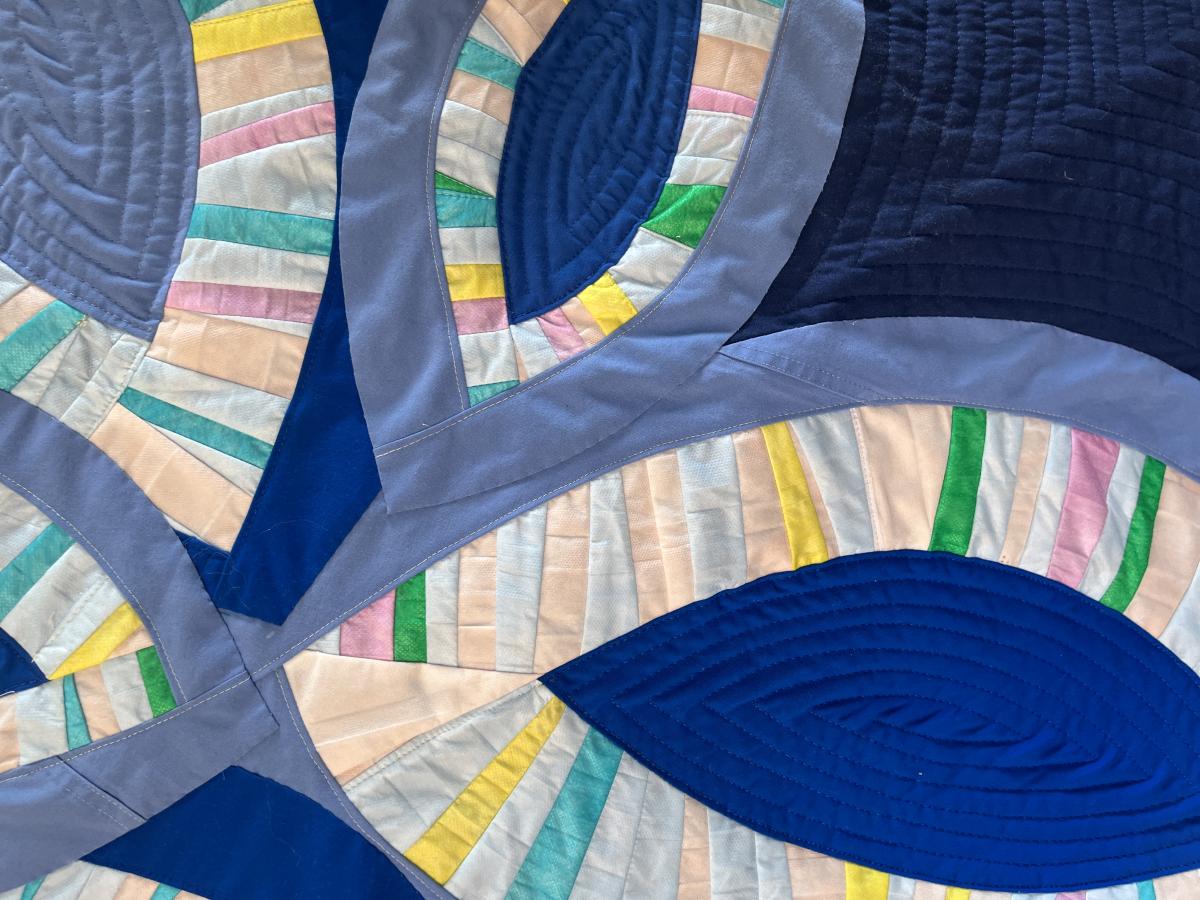 close up of quilted art piece made with multiple colorful materials