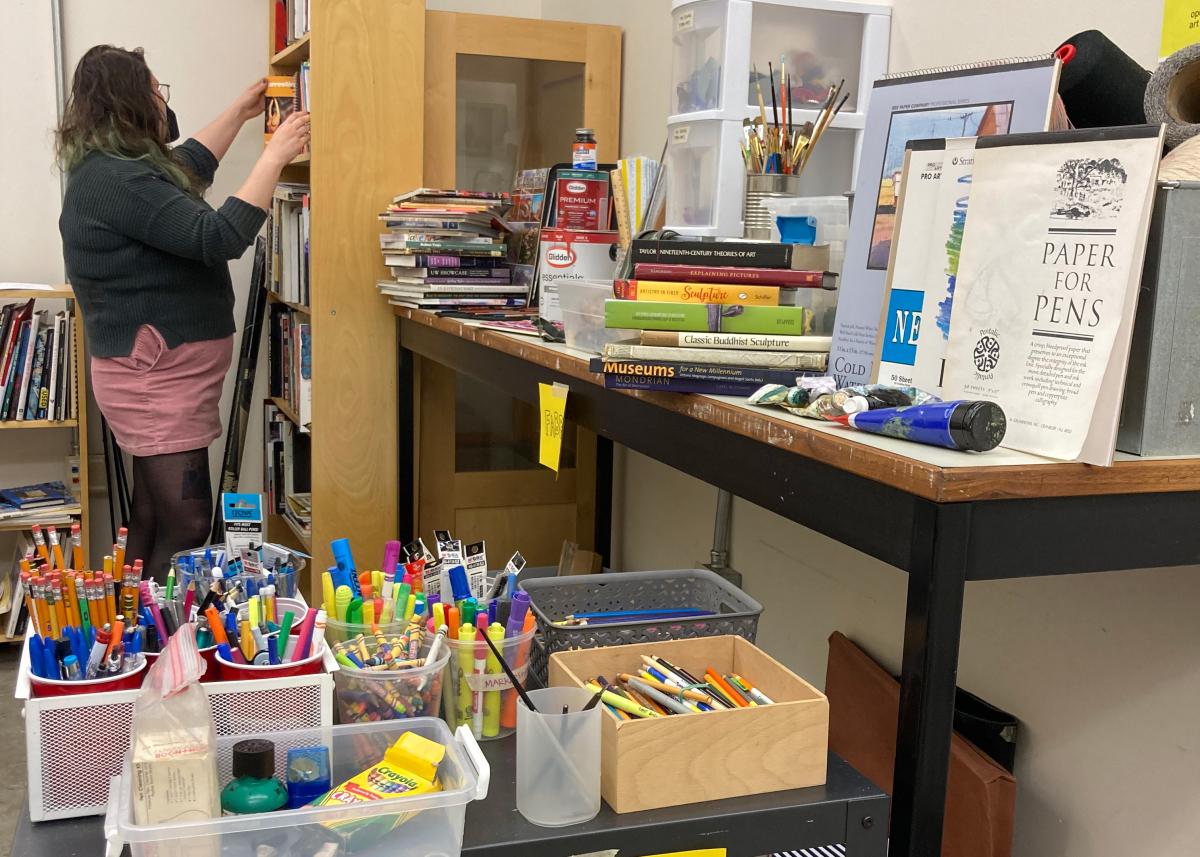 a person stacking books in the uw free materials library