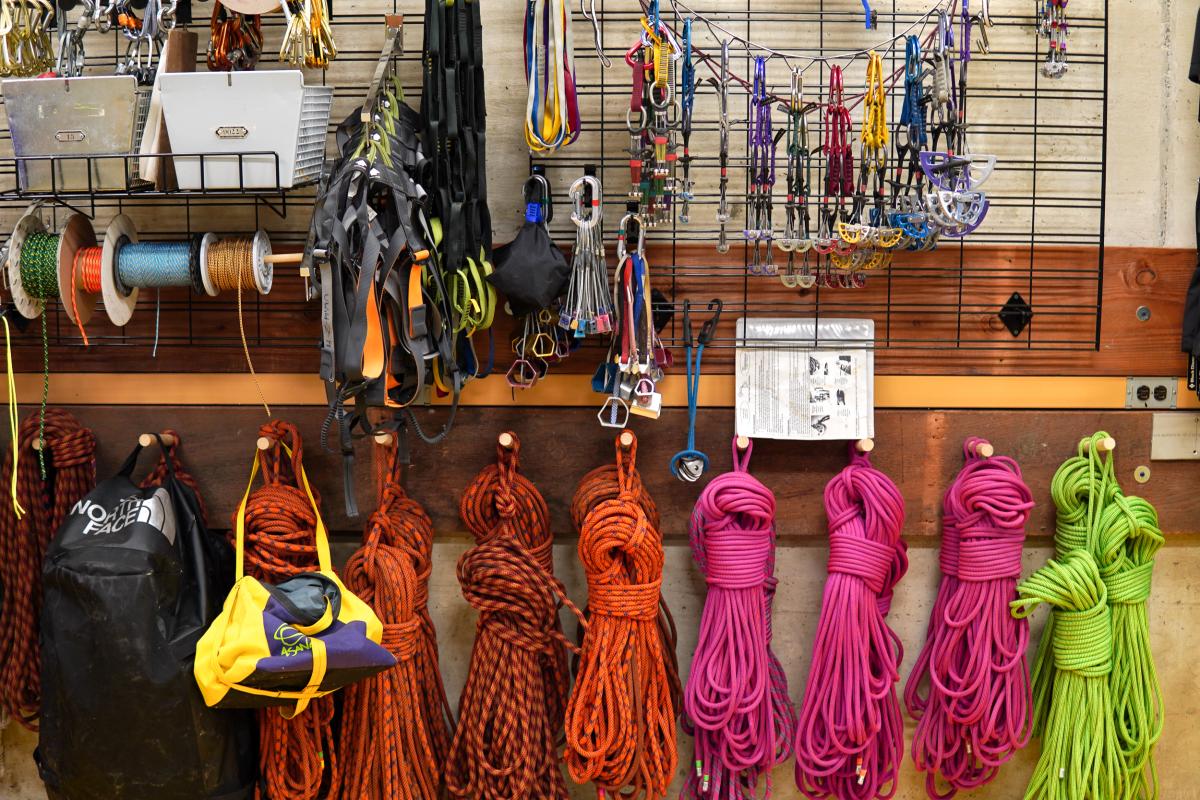 lots of rock climbing gear on a wall shelf