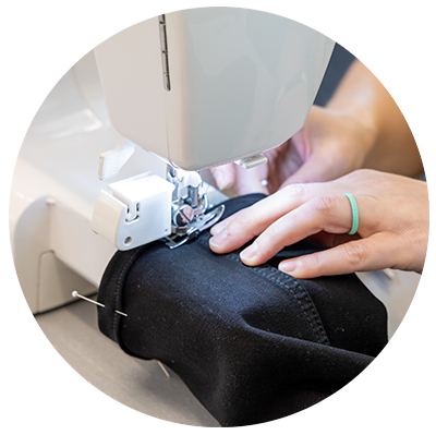 a person's hands sewing a garment on a sewing machine