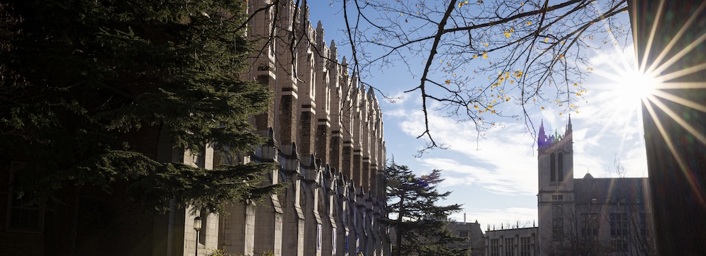 view of Suzzallo Library and Gerberding Hall with bright sun behind