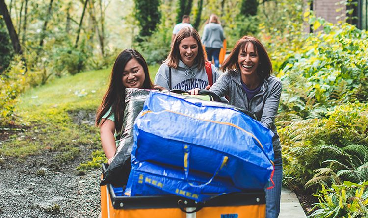 smiling people moving cart full of luggage