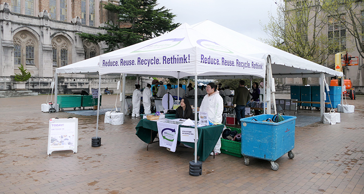 tent with uw recycling text with two people standing in front of it on red square