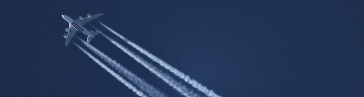 plane and contrails against blue sky