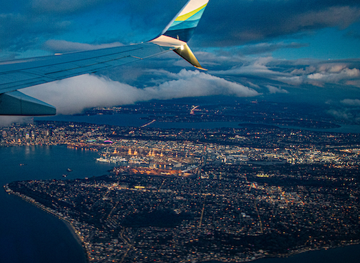 view of airplane wing in sky over Seattle